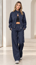 Front full-length view of woman wearing navy blue zip-up jacket and wide-leg tracksuit set