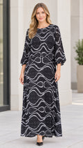 Front view of model wearing black abstract wave print maxi dress with long sleeves