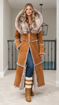 Front full view of woman wearing long camel faux suede coat with faux fur hood
