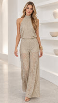 Full-length front view of woman wearing a beige lace halter wide leg jumpsuit