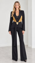 Front view of model wearing black tailored suit set with contrast pleated waist detail