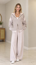 Front full view of model wearing Oatmeal cable-knit zip-up hooded cardigan with wide-leg pants