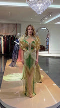 Full front view of emerald green and gold beaded evening gown with feathered shoulders
