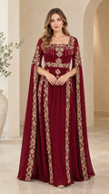 Front view of model wearing burgundy cape sleeve evening gown with gold embroidery