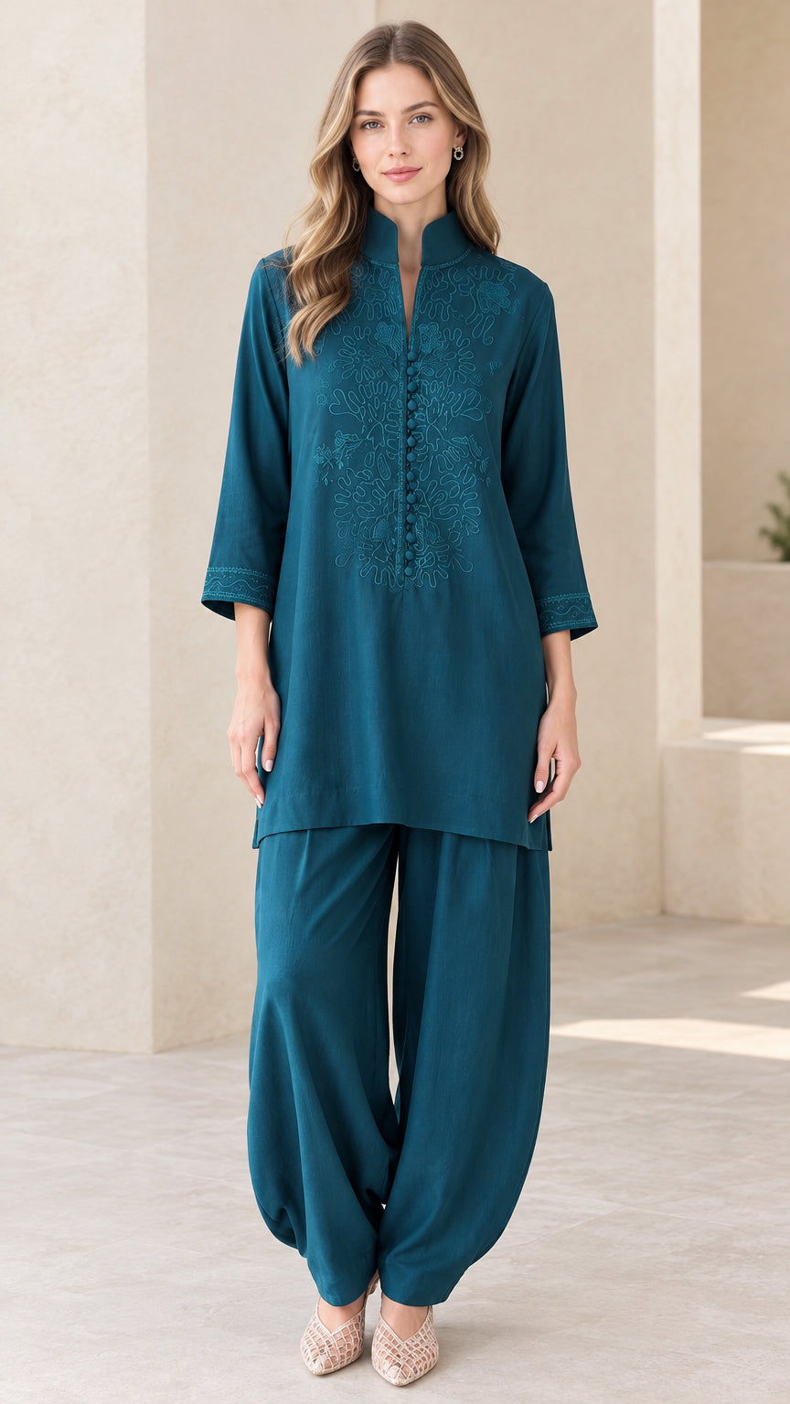 Front view of woman wearing Teal embroidered tunic and draped pant set