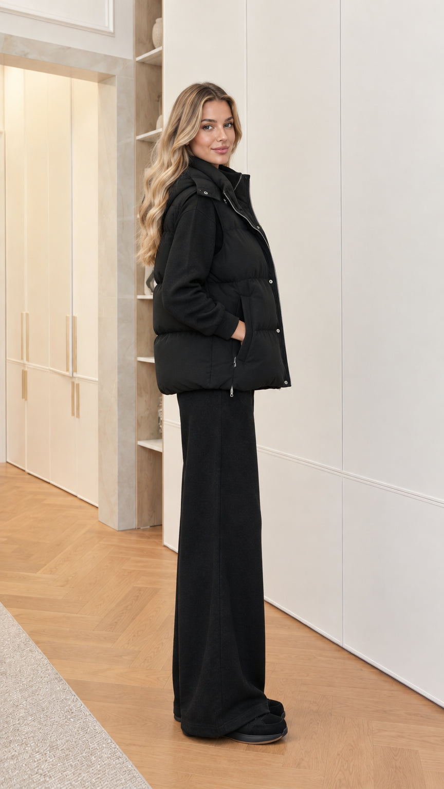 Side profile of woman wearing black 3-piece puffer vest and lounge set