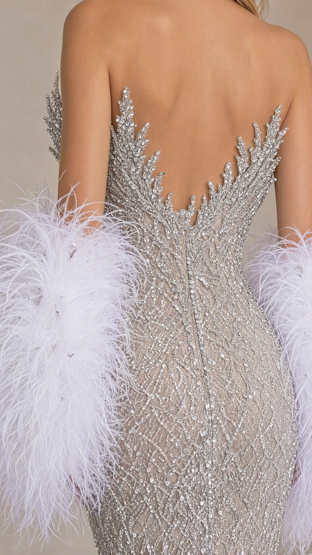 Close-up back detail of silver beaded bodice and plush feather sleeve cuff