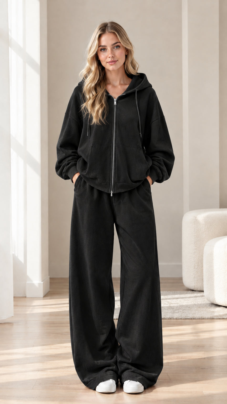 Woman wearing black zip-up hoodie and wide-leg sweatpants two-piece set